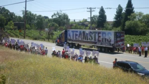 Teamsters truck with a picket line on either side of the road