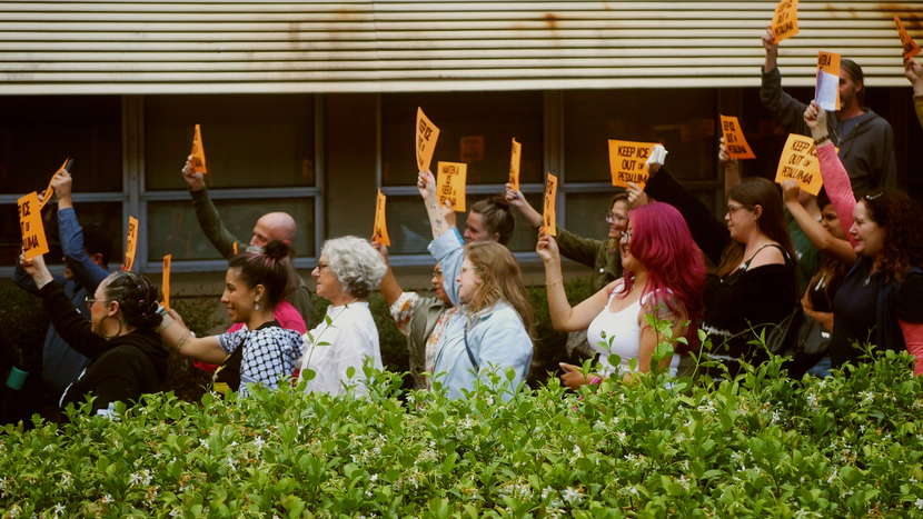 People with signs pose for a photo.